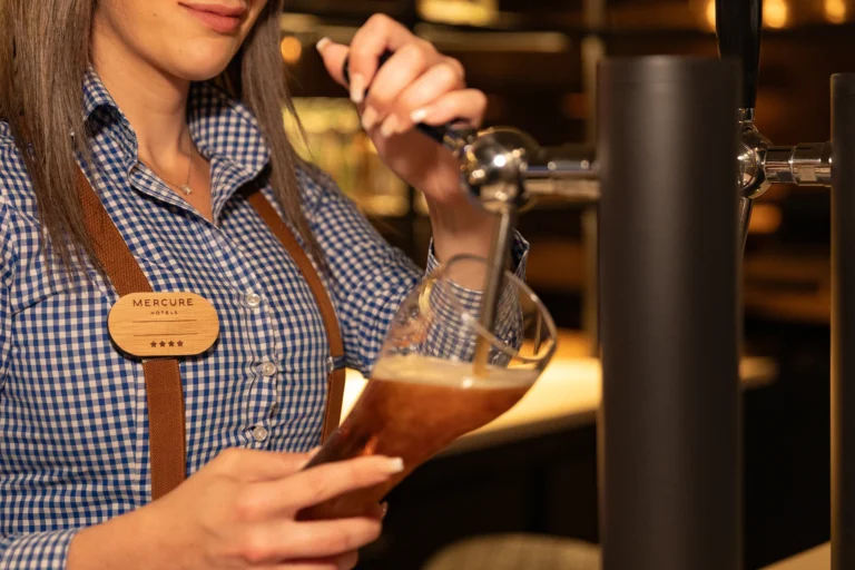 Photographie de barmaid servant une bière pression, geste de service en bar, hôtel Mercure Luxembourg Off Kirchberg, par Armando Garcia