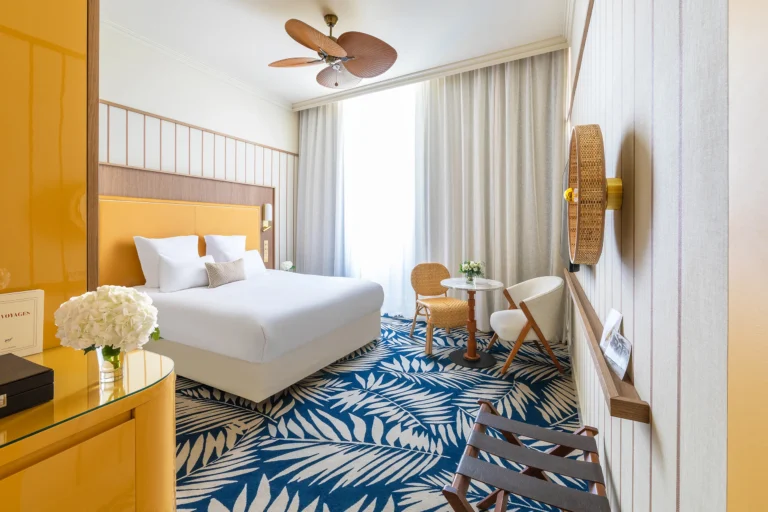 Chambre d’hôtel lumineuse avec coin salon et moquette à motif graphique, photographie d’architecture intérieure – Grand Hôtel Beauvau MGallery Marseille
