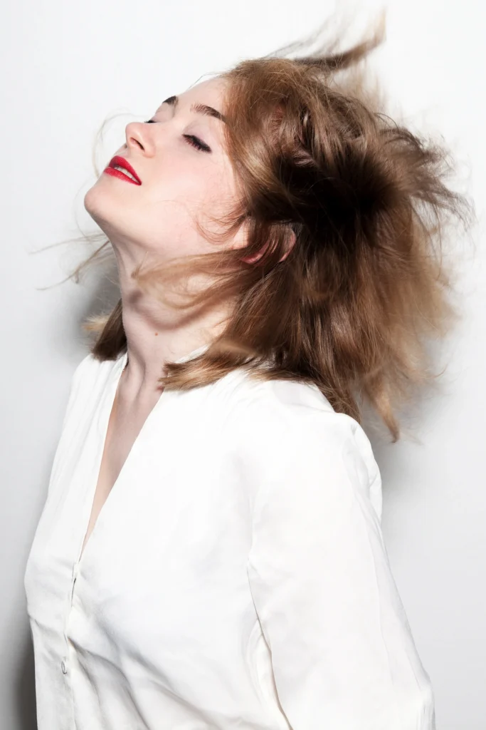 Portrait éditorial en studio d’une femme en mouvement, ambiance claire et dynamique, photographie réalisée par Armando Garcia